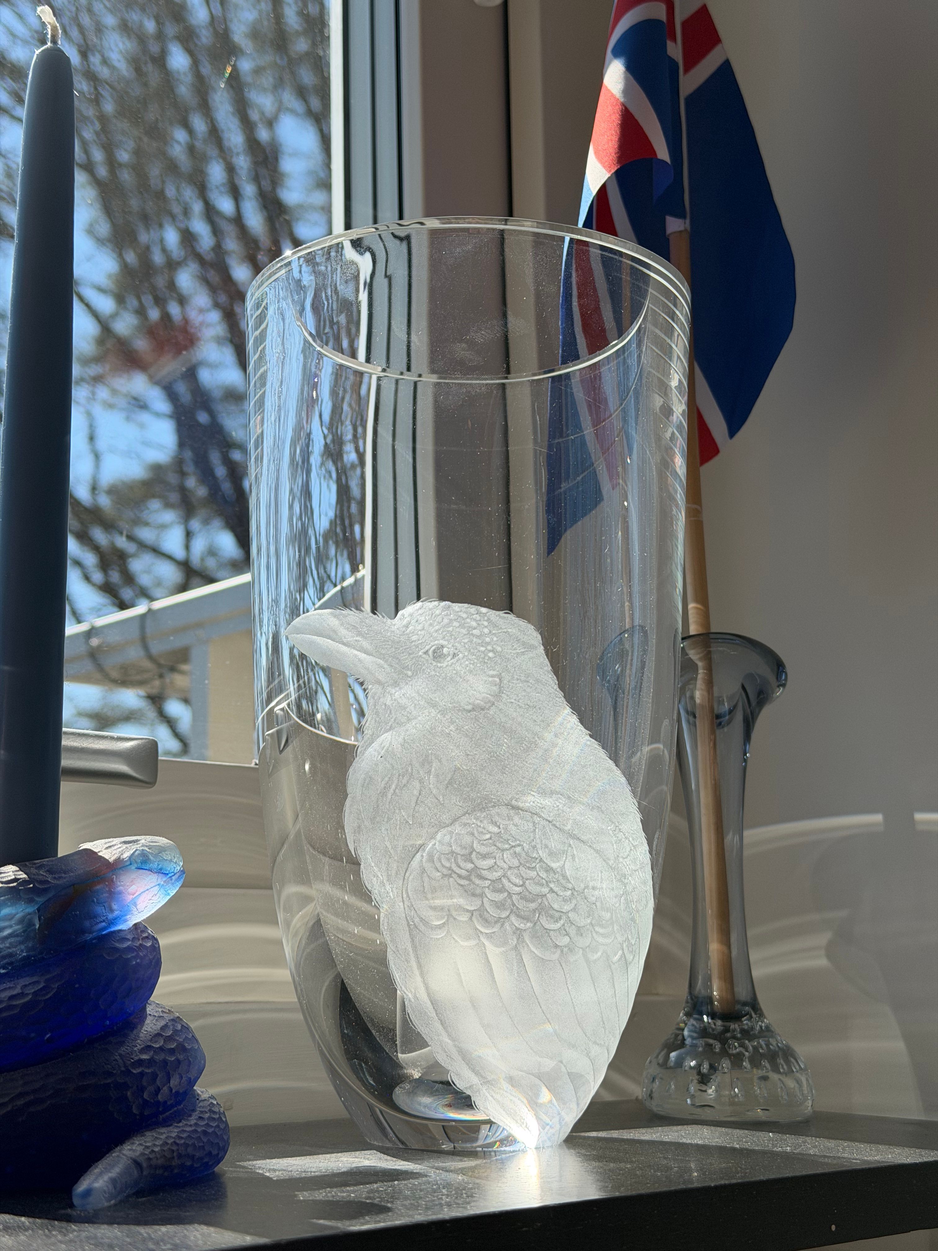 Raven engraved into a frosted glass vessel